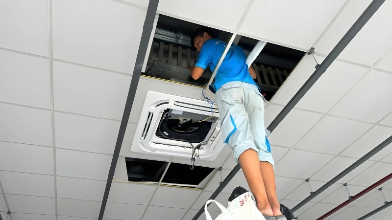Kỹ thuật viên đang tháo mặt vỏ dàn lạnh để kiểm tra